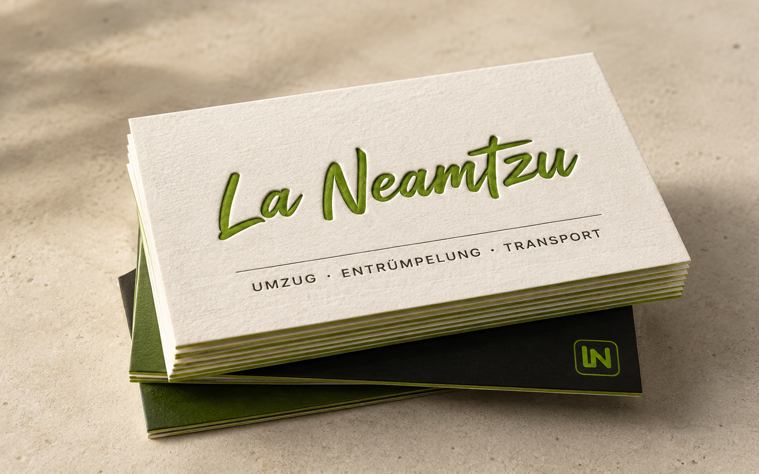 Visitenkarten von La Neamtzu, ausgestanzt freigestellt: Wortmarke auf der Vorderseite, Kontaktdaten auf der Rückseite