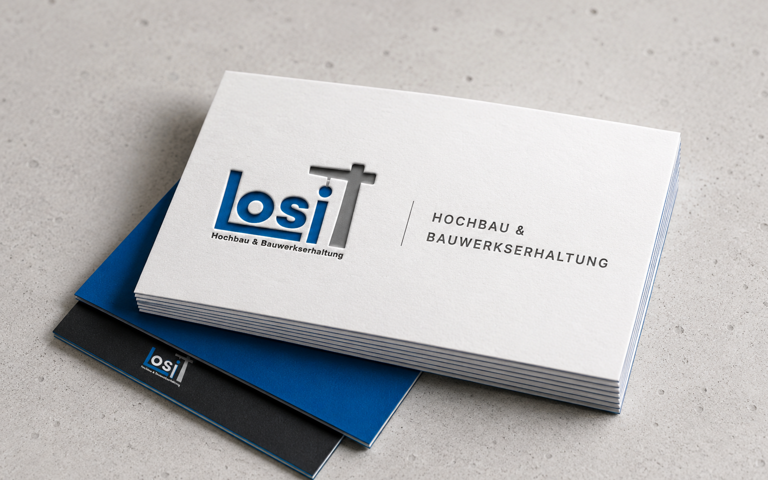 Visitenkarten von Losi Bau, ausgestanzt freigestellt: Wortmarke auf der Vorderseite, Kontaktdaten auf der Rückseite
